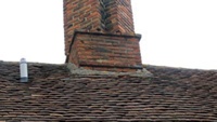 Mortar fillets are commonly used at the junction between peg tiles and a chimney (shown here), but lead flashings (shown below) are much more reliable.